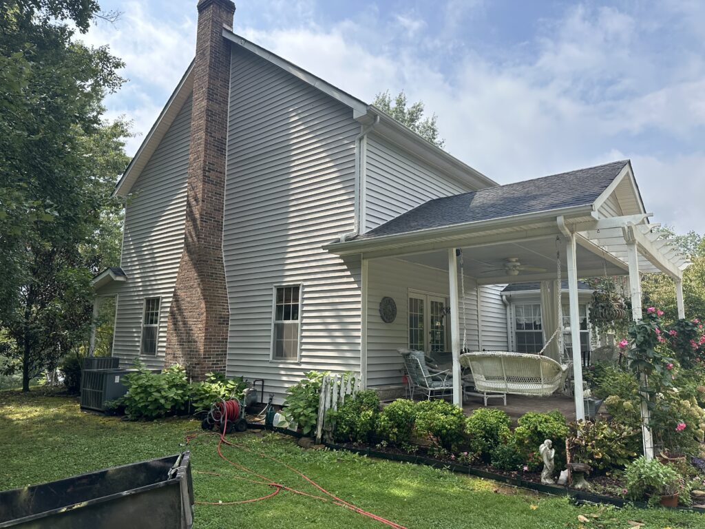 Water damage and wet wood rafters near a chimney stack inside a Knoxville attic.