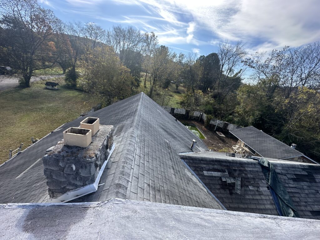 Technical close-up of a blown-off shingle showing improper high nailing, a common cause of roof failure in Knoxville.