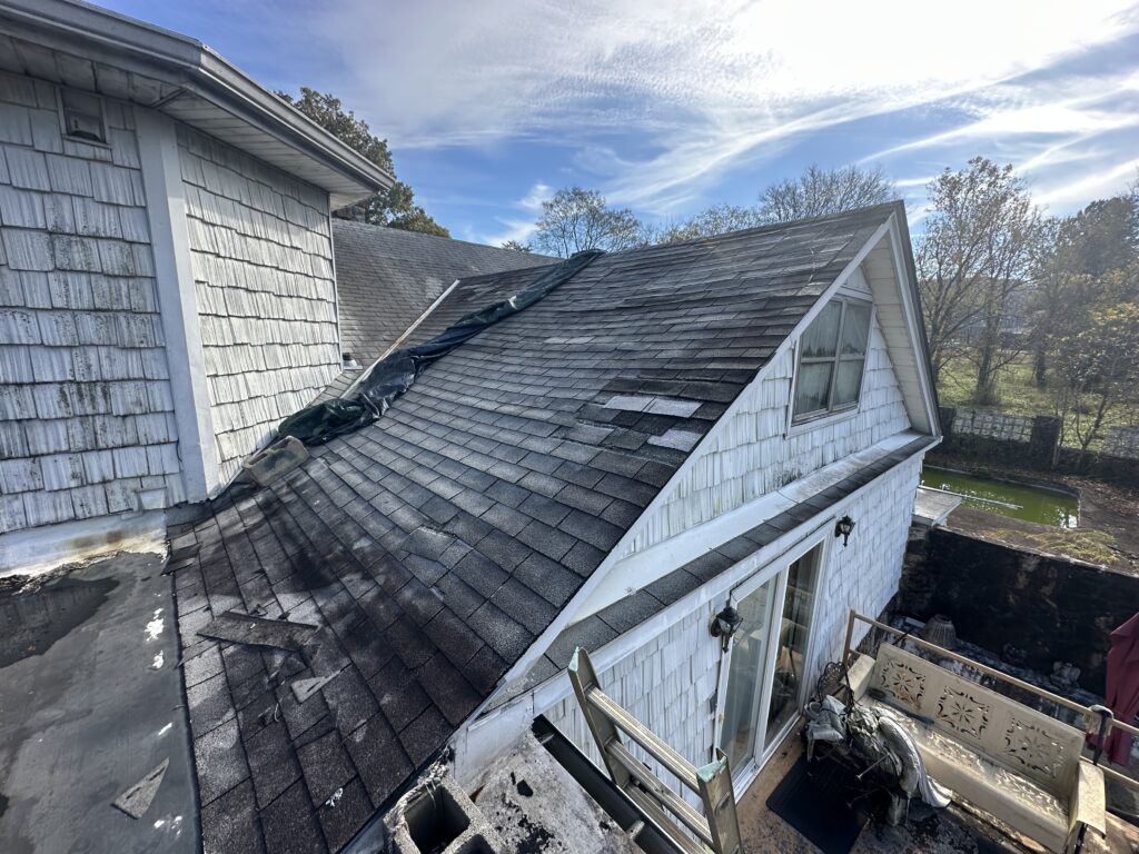 Missing roof shingles found in a residential yard after a wind storm in Knoxville TN, showing immediate need for repair.