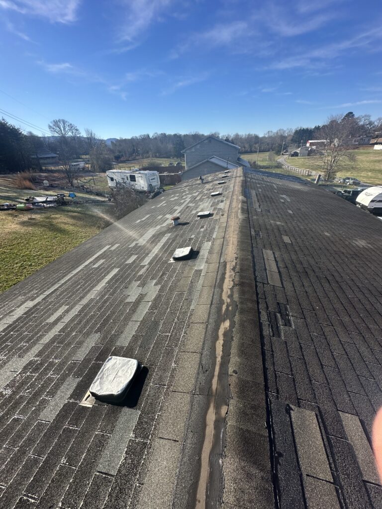 A contractor's truck with ladders parked in front of a house during light rain in Knoxville.