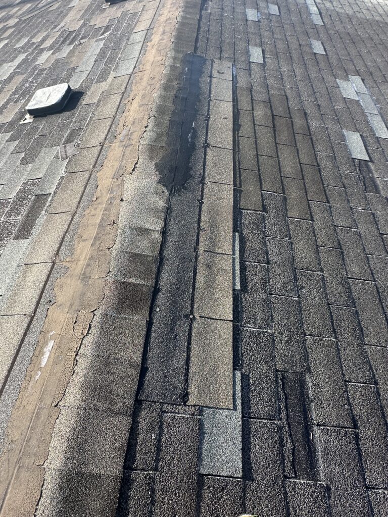 Daylight filtering through a gap in a dark attic ceiling after storm damage in Knoxville.