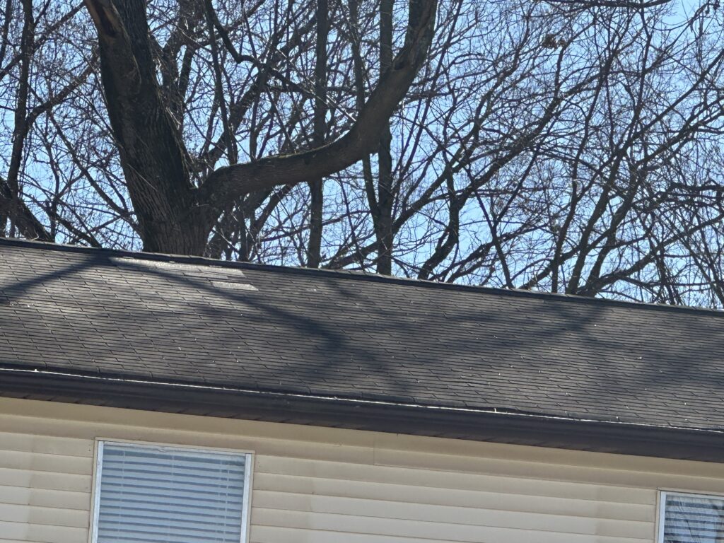 A contractor's hand applying sealant around a damaged roof pipe boot in Knoxville.