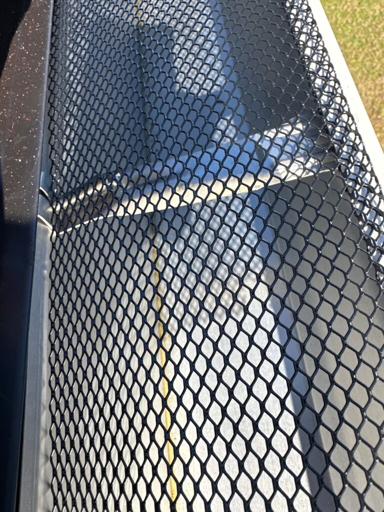 Close-up of a black diamond-mesh gutter guard fitted over a white gutter on a Knoxville, TN home