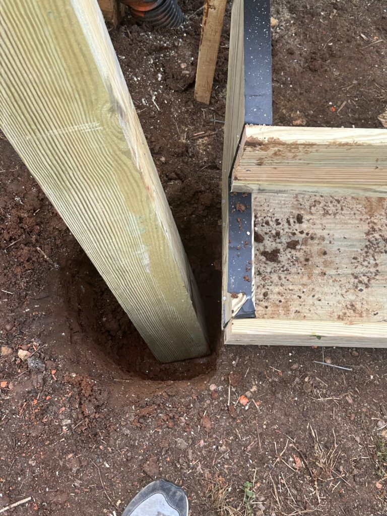 Detailed texture of soft, spongy wood rot and dark mold growth on a structural deck post in Knoxville, TN.