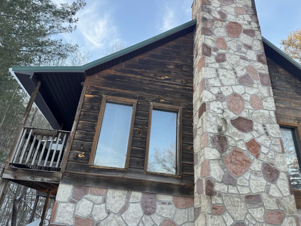 Inspecting damaged siding and trim to find the source of window water leaks.