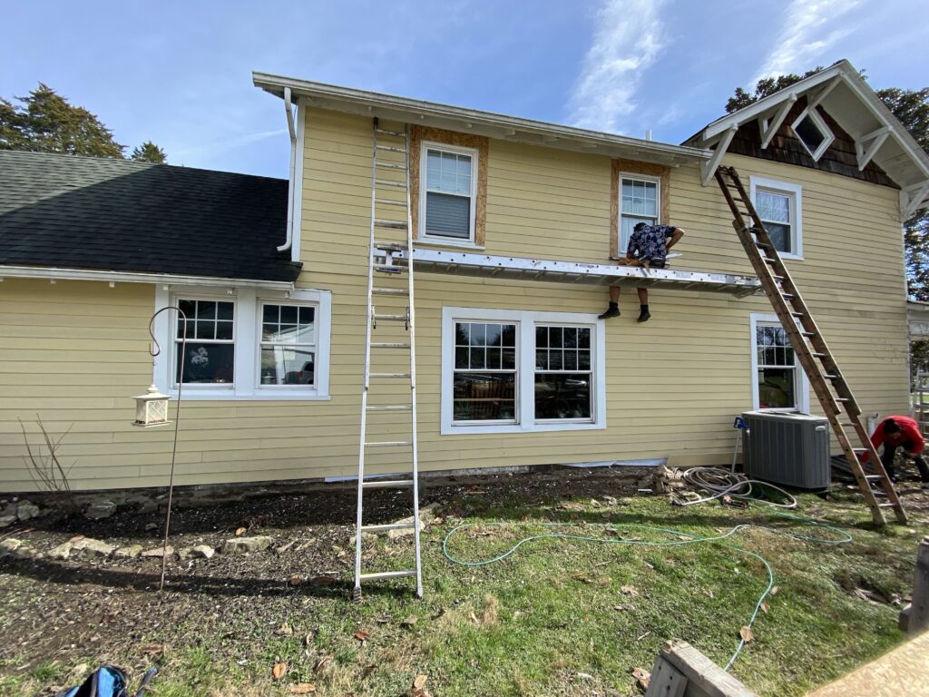 Replacing cracked window caulking to stop water and air leaks.