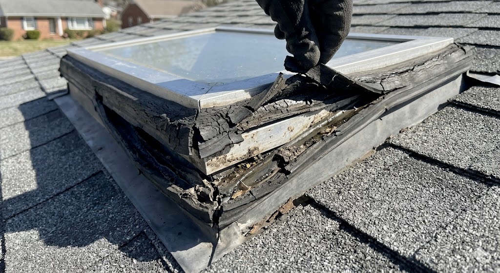 Mid-range interior shot of water stains and bubbling drywall around a residential skylight in Knoxville.