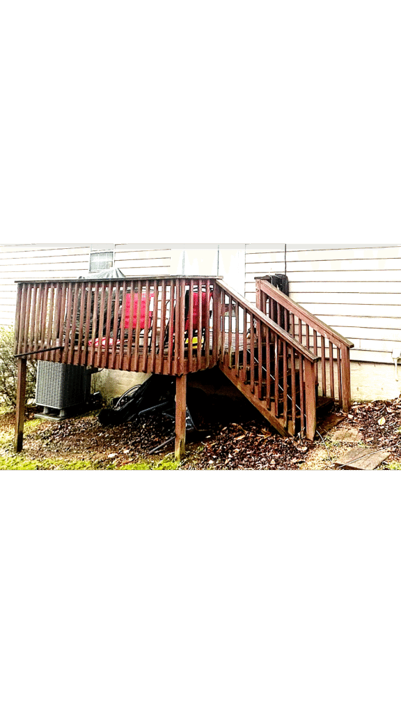 Inspecting a rotted wood deck post caused by moisture.