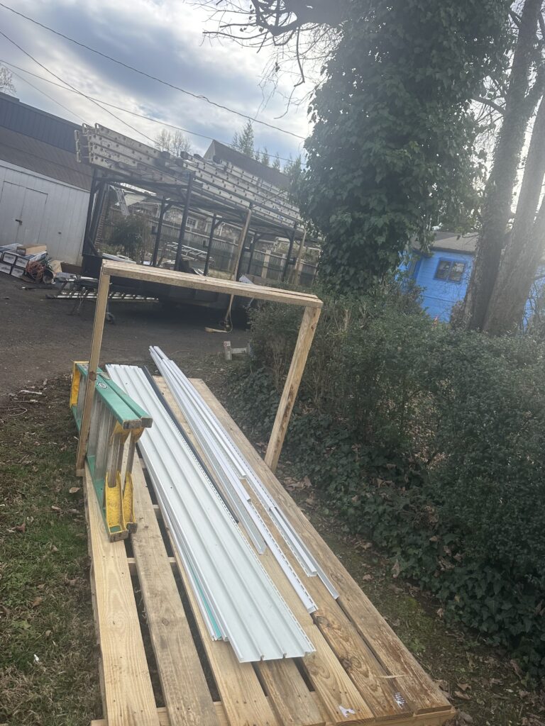 A section of a Knoxville home with new, dark gray premium vinyl siding installed, featuring precision-cut corners and professional trim work.