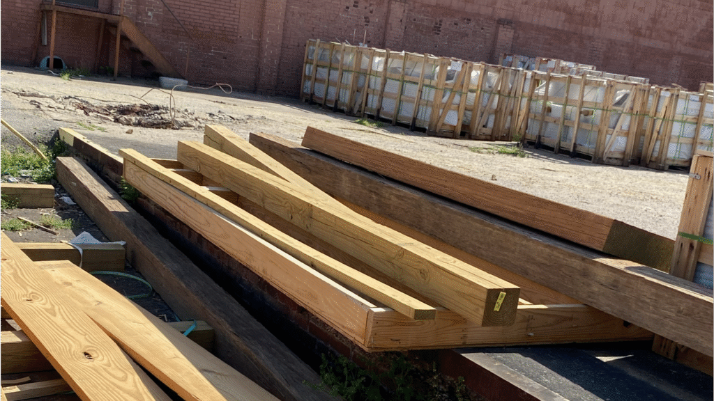 Dos instaladores de MI Homesiding & Roofing colocan siding de madera tratada LP SmartSide de ExpertFinish en una casa en Knoxville, TN, enfocándose en el sellado de humedad.