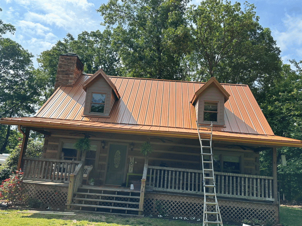 Log cabin with a copper standing seam metal roof and covered porch in East Tennessee
