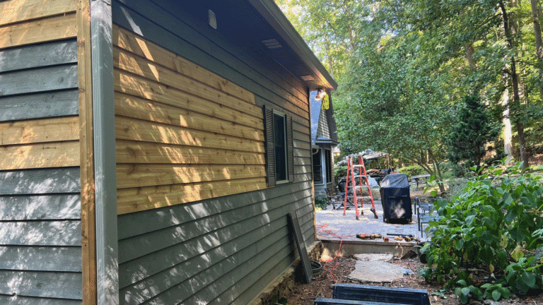 Wood siding rotting at the bottom due to soil contact and moisture.