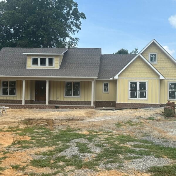 Newly finished single-story yellow home with a covered porch in East Tennessee