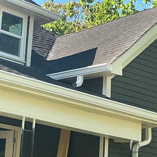 New white gutter along the eave of a dark green home with white trim in Knoxville, TN