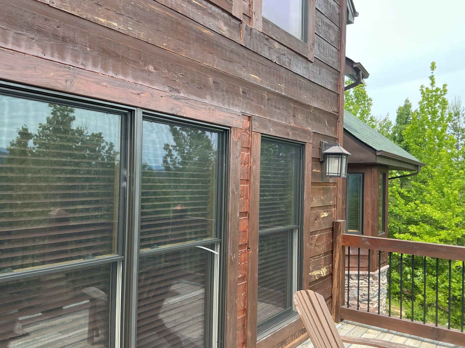 Dark stained wood home with large windows and a covered deck in East Tennessee