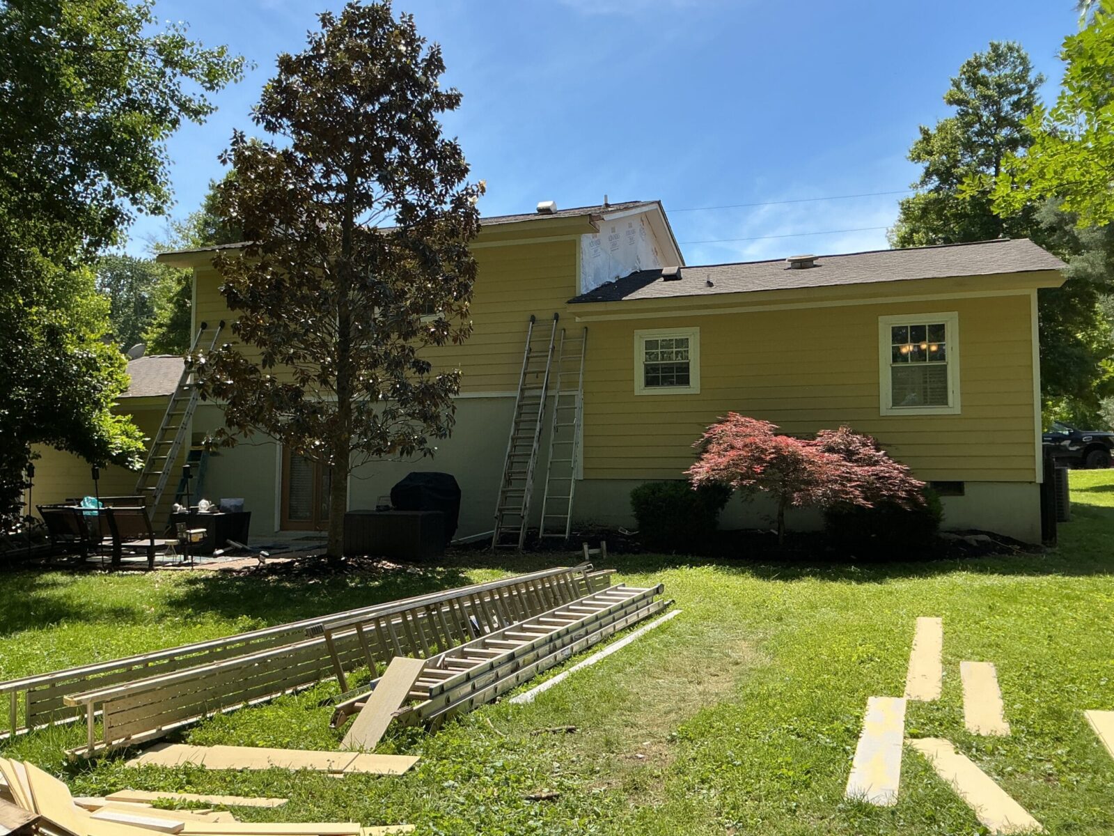 Siding replacement under way on a ranch home, with a gable section opened back to the housewrap