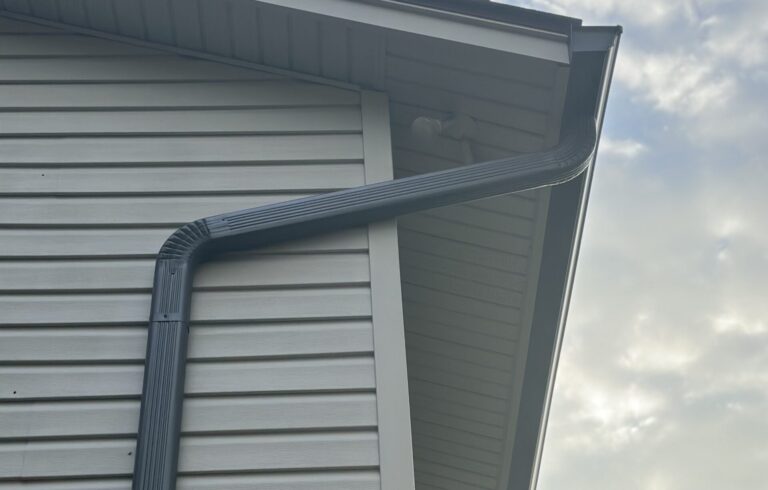 Close-up of shifted gutter pitch and loose hangers caused by wind and hail impact.