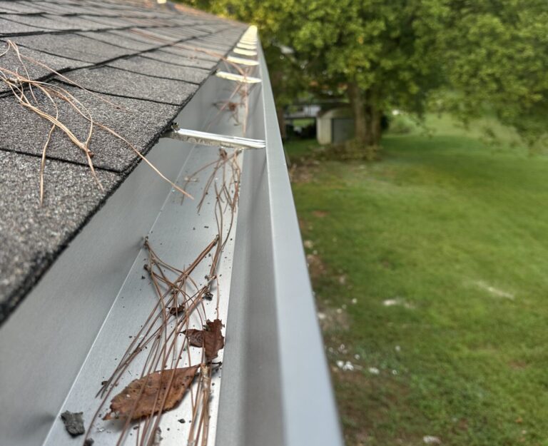 Checking fascia integrity for wood rot behind damaged gutters during a storm repair project.