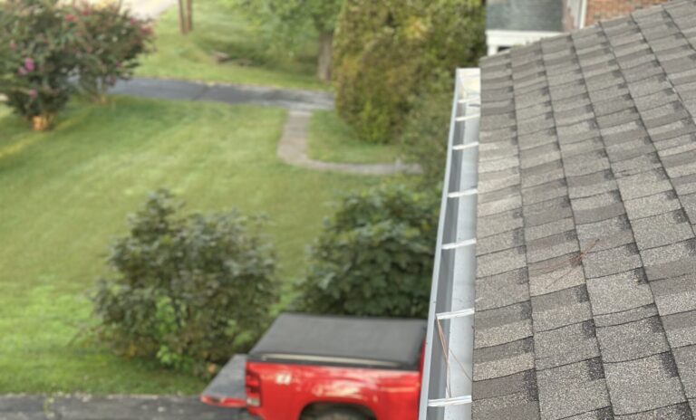 MI Homesiding professional inspecting a gutter pulled loose from the fascia after a storm in Knoxville.