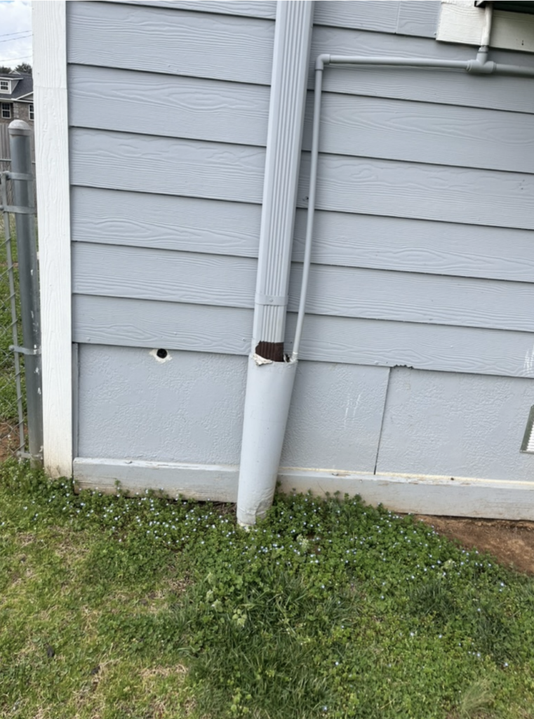 Technical view of hail dents and alignment issues on a residential gutter system.
