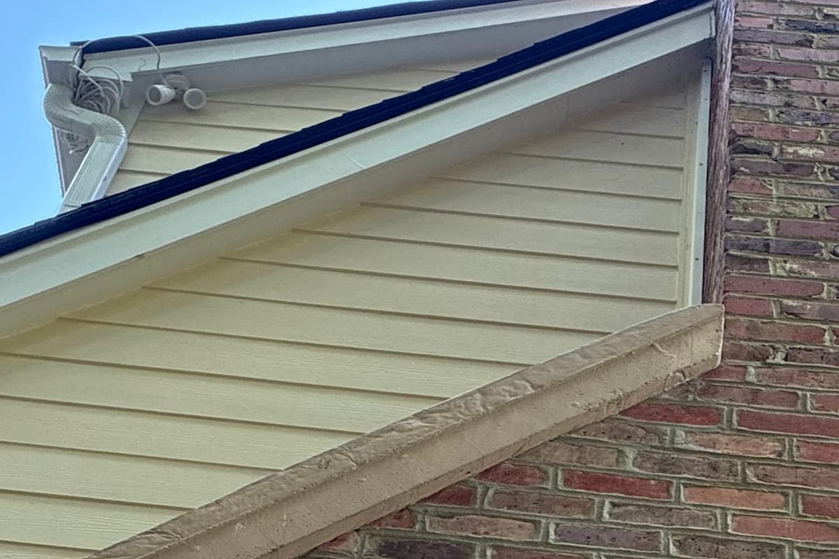 Newly installed James Hardie lap siding meeting a brick wall at the gable of a Knoxville, TN home