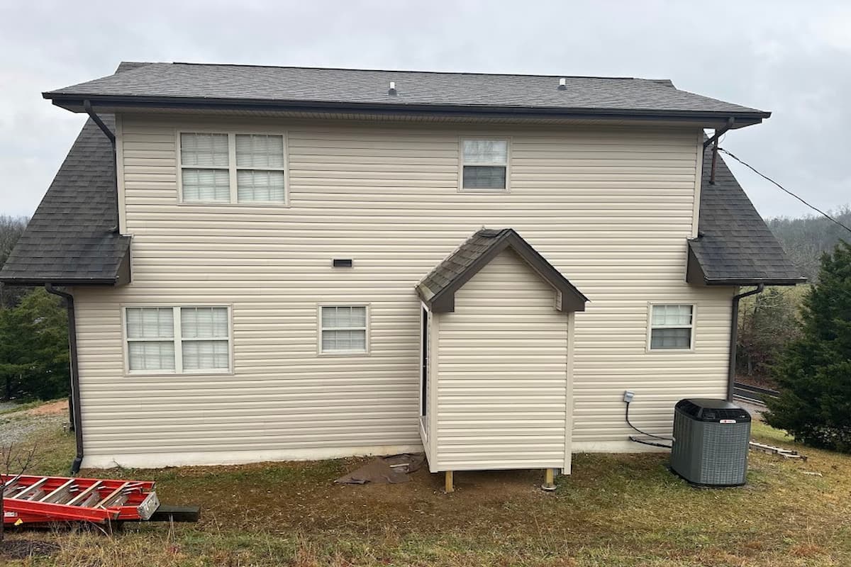 Two-story home with new cream vinyl siding after replacing old wood siding in Sevierville, TN