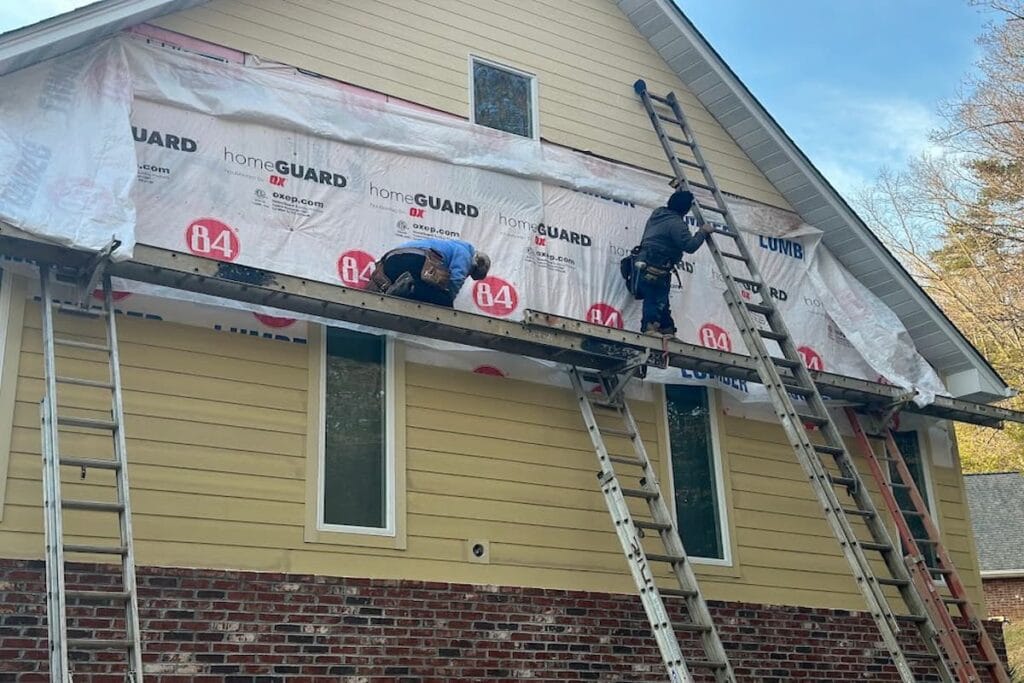 Crew installing James Hardie siding over housewrap on the gable of a Knoxville, TN home