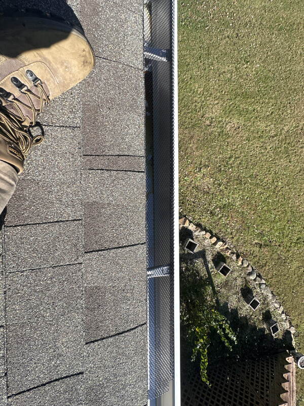 Black diamond-mesh gutter guard running along the gutter at the shingle roof edge of a Knoxville, TN home